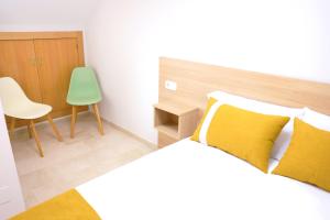 a bedroom with a bed and a green chair at Apartamentos VeraVibe in Caravaca de la Cruz