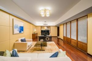a living room with a couch and a tv at The Imperial Mansion, Beijing - Marriott Executive Apartments in Beijing