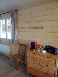 a room with a wooden wall with a wooden dresser and a chair at Equi-Lodge in Parleboscq +5 photos