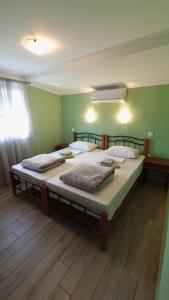 two large beds in a room with green walls at House Eugenia Sarti in Sarti