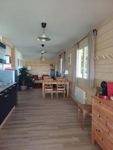 a kitchen and living room with a table and chairs at Equi-Lodge in Parleboscq