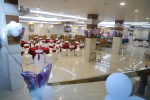 a banquet hall with red and white tables and balloons at The Grand Oasis Hotel & Resort I Near India Expo Mart in Greater Noida +30 photos
