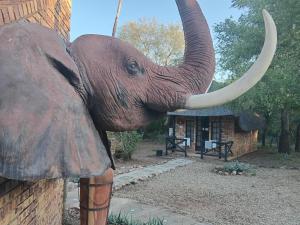 an elephant statue with its trunk on a building at Elephant Memories wildlife lodge in Marloth Park