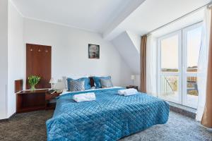 a bedroom with a bed with a blue comforter and a window at Willa Wodnik in Świnoujście +127 photos