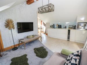 a living room with a couch and a tv at Rose Apartment - Gower in Swansea