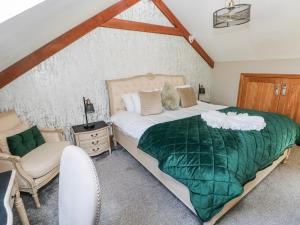 a bedroom with a large bed and a chair at Rose Apartment - Gower in Swansea