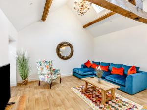 a living room with a blue couch and a table at The Granary - Uk38980 in Llandyssil