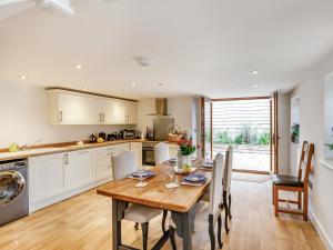 a kitchen and dining room with a wooden table and chairs at The Granary - Uk38980 in Llandyssil