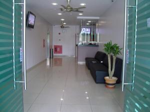 a living room with a couch and a potted plant at Hotel Orient in Johor Bahru