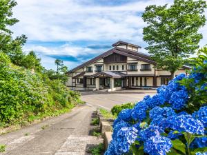 a house with blue flowers in front of a road at Eshin no Sato Yasuragisou in Joetsu