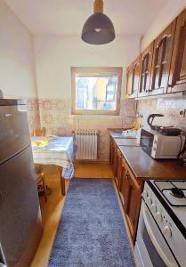 a kitchen with a refrigerator and a table in it at Panorama Sky Apartment -11 min by walk to Old Town - Free Parking in Sarajevo +25 photos
