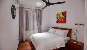 a bedroom with a white bed and a ceiling fan at Villa Barracuda in Sri Jayewardenepura Kotte +30 photos