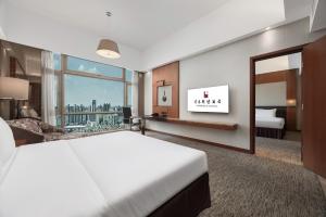 a hotel room with a bed and a large window at Vanburgh Hotel Guangzhou in Guangzhou