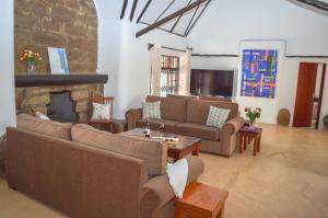 a living room with couches and a fireplace at Maanzoni - Ndoto House ,Athi River by Nest & Nomad in Machakos