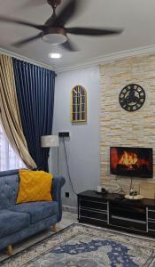 a living room with a blue couch and a fireplace at Homestay Santai Bertam in Kepala Batas +42 photos