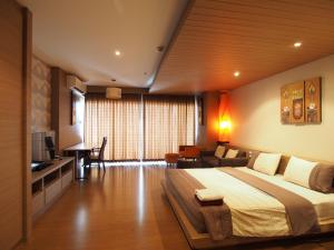 a bedroom with a large bed and a living room at View Talay 6 by Pat 42 in Pattaya Central