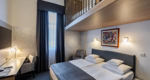 a hotel room with a bed and a desk at Best Western Airport Hotel Stella in Zagreb +49 photos