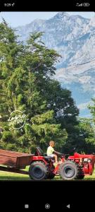 a man on a tractor pulling a trailer at Čemerno Mountain House in Gacko