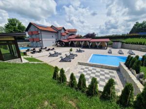 a swimming pool with lounge chairs and a resort at Plitvice Palace Rooms - Adults Only in Grabovac