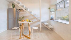 a small kitchen with a table and a refrigerator at gyeongju planb pet pension in Gyeongju