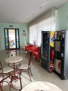 a restaurant with a soda machine and tables and chairs at Hotel Anita B&B sul lungomare in Gatteo a Mare