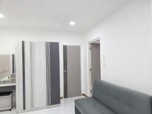a living room with a couch and a mirror at Hugg daily airport 1 in Samutprakarn