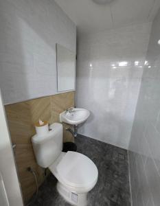 a bathroom with a white toilet and a sink at Hugg daily airport 1 in Samutprakarn +1 photo