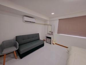 a living room with a couch and a chair at Hugg daily airport 1 in Samutprakarn