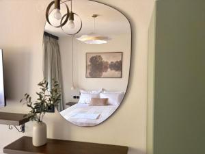 a mirror in a bedroom with a bed in it at Noima Kalamitsi Boutique Studios in Kalamitsi +45 photos