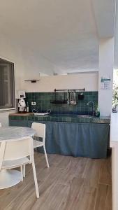 a kitchen with a table and some chairs and a counter at Residenza Villa Terry in Vieste