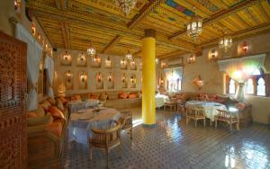 a restaurant with tables and chairs in a room at OZ Palace Ouarzazate & SPA in Ouarzazate
