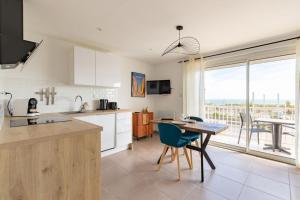 a kitchen with a table and a dining room at "La Sorra" Résidence en Bord de mer in Saint-Cyprien