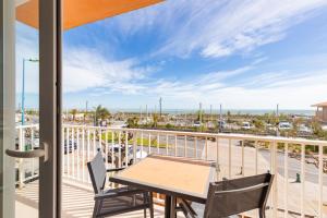 a balcony with a table and chairs and a view of the ocean at "La Sorra" Résidence en Bord de mer in Saint-Cyprien