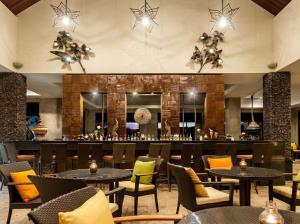 a restaurant with tables and chairs and a bar at Katiliya Park Villa in Mae Chan