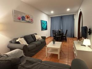 a living room with a couch and a table at Sanmao Vibbecanarias Playa del hombre Telde in Playa del Hombre