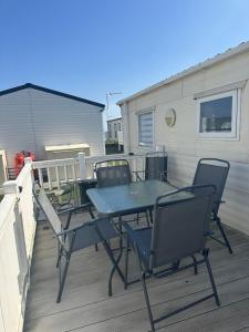 a patio table and chairs on a deck at Seaside views in North Seaton