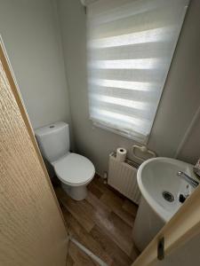 a small bathroom with a toilet and a sink at Seaside views in North Seaton