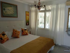 a bedroom with a bed with white walls and windows at Milkwood Haven in Pennington