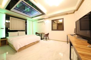 a bedroom with a bed and a flat screen tv at 호텔야자 담양점 신관 in Kasan-ni