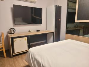 a room with a bed and a desk with a television at 호텔야자 담양점 신관 in Kasan-ni