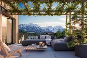 a patio with couches and a view of mountains at Wieshof Wilder Kaiser by ALPS RESORTS in Söll