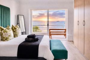 a bedroom with a bed with a view of the ocean at Sunset View 23 in Langstrand