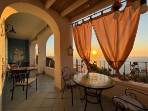 a balcony with tables and chairs and a view of the ocean at Belvedere in Castro di Lecce