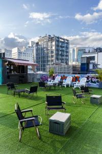 a group of chairs and tables on a field of grass at Bluedot Poshtel in Seoul