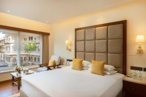 a large bedroom with a large white bed with yellow pillows at Gateway Kandla Gandhidham in Gandhidham