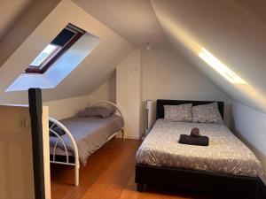 a attic bedroom with a bed and a window at La maison penchée in Rosny-sous-Bois