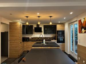 a kitchen with a black counter top and a sink at La maison penchée in Rosny-sous-Bois