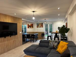 a living room with a couch and a dining room at La maison penchée in Rosny-sous-Bois