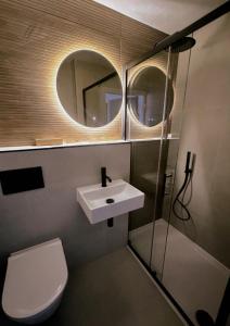 a bathroom with a sink and a toilet and a mirror at Glass Tower - By Central Beach Leisure in Blackpool