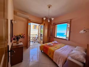 a bedroom with a bed and a view of the ocean at Avra Apartments in Leonidio